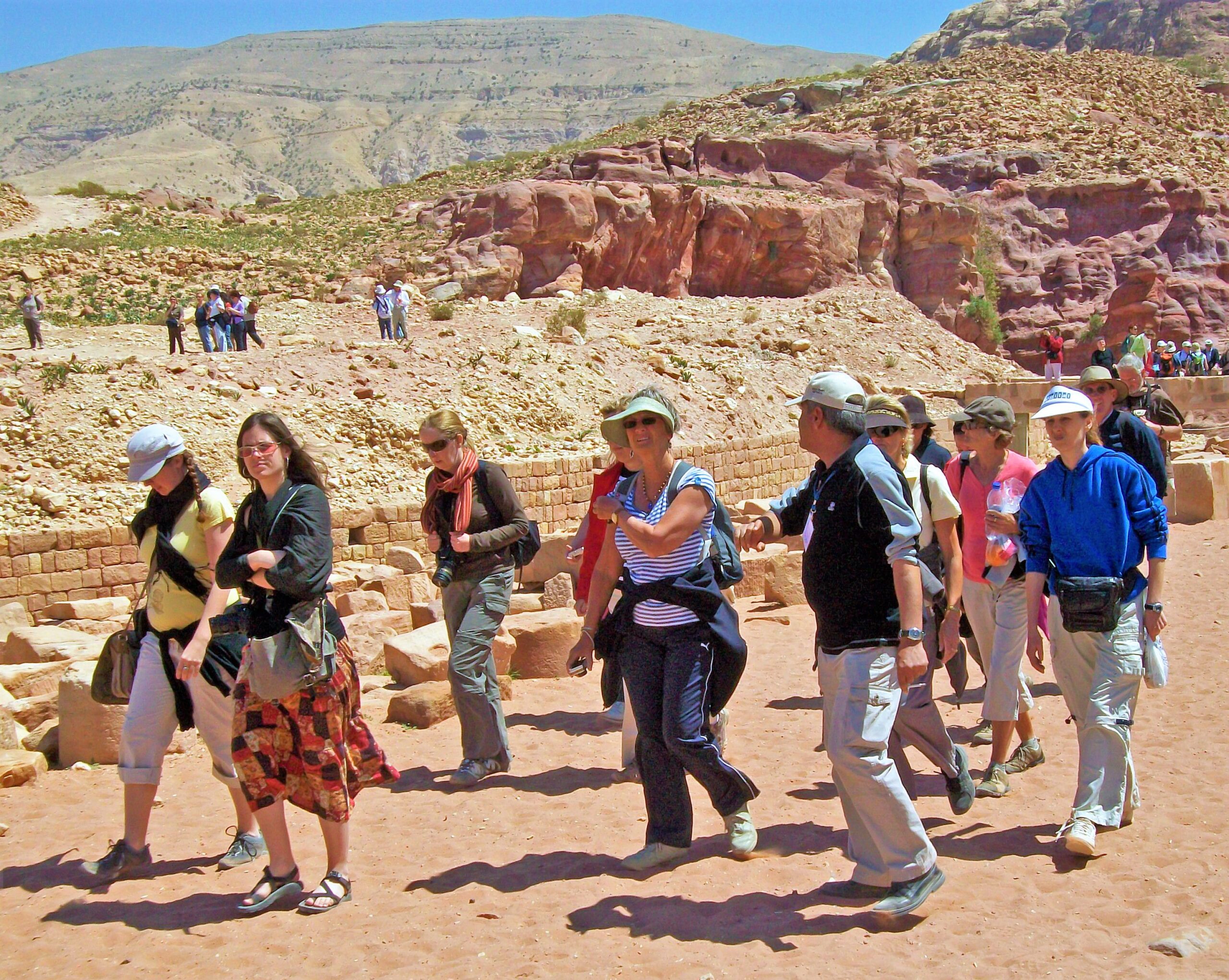 Tourists gathered with a guide in the lower canyon at Petra, Jordan.